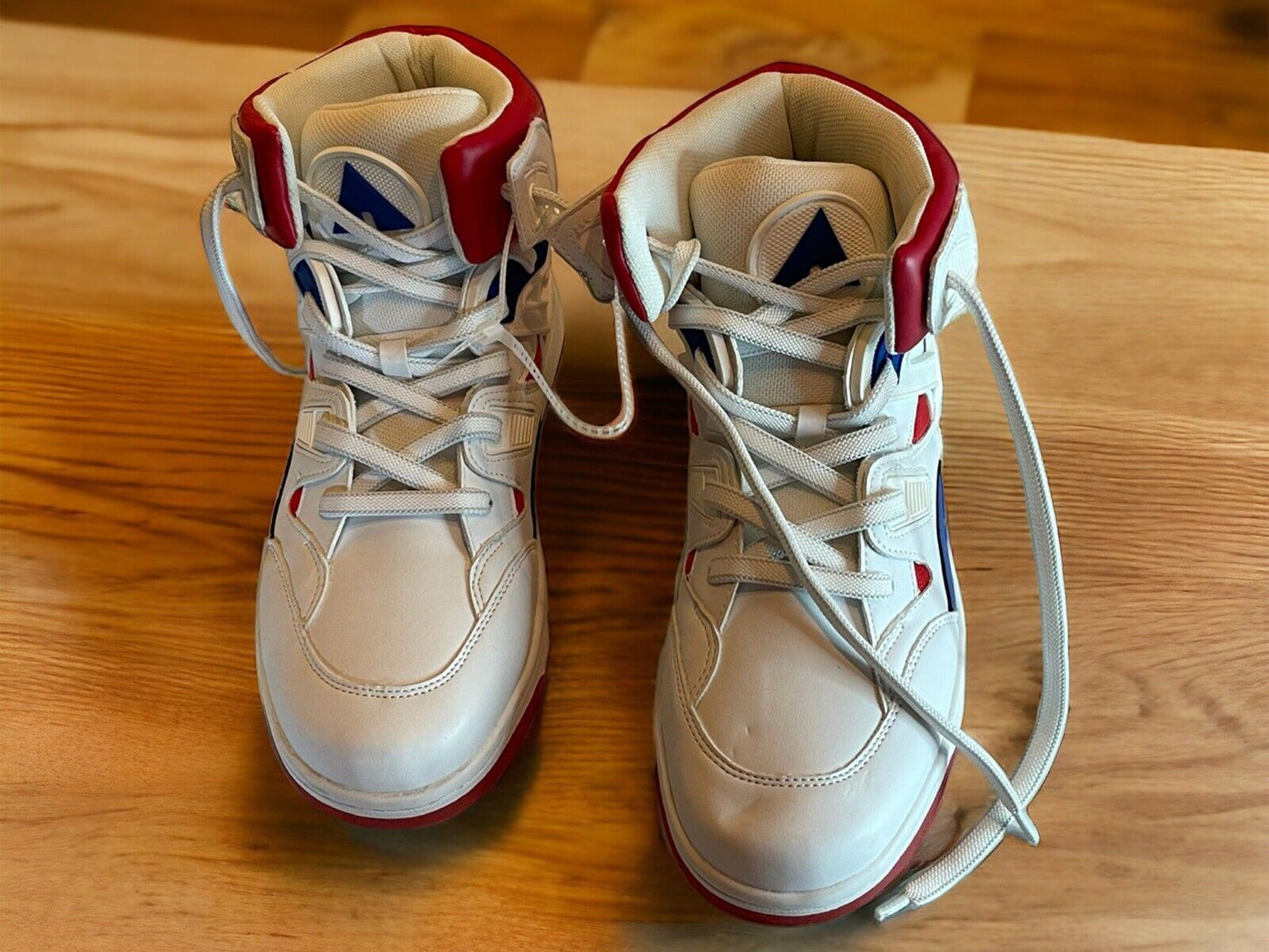 White and red Airwalk men’s sneakers size 9.5 with high-top design and laces on wooden floor