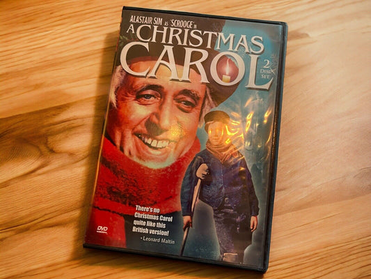 A Christmas Carol DVD set featuring Alastair Sim as Scrooge with a red scarf and a character holding a cane