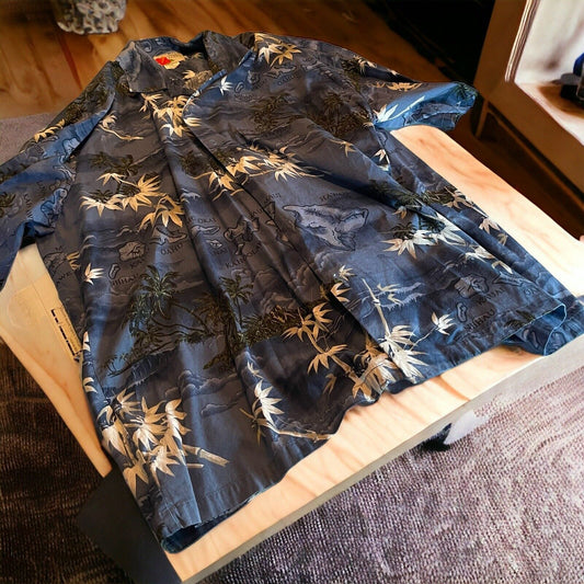 Ali’i blue tropical shirt with bamboo and island print laid out on wooden surface
