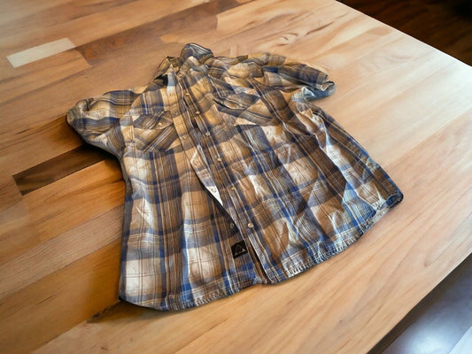 Americaware snap button shirt in blue and beige plaid pattern laid flat on wooden table