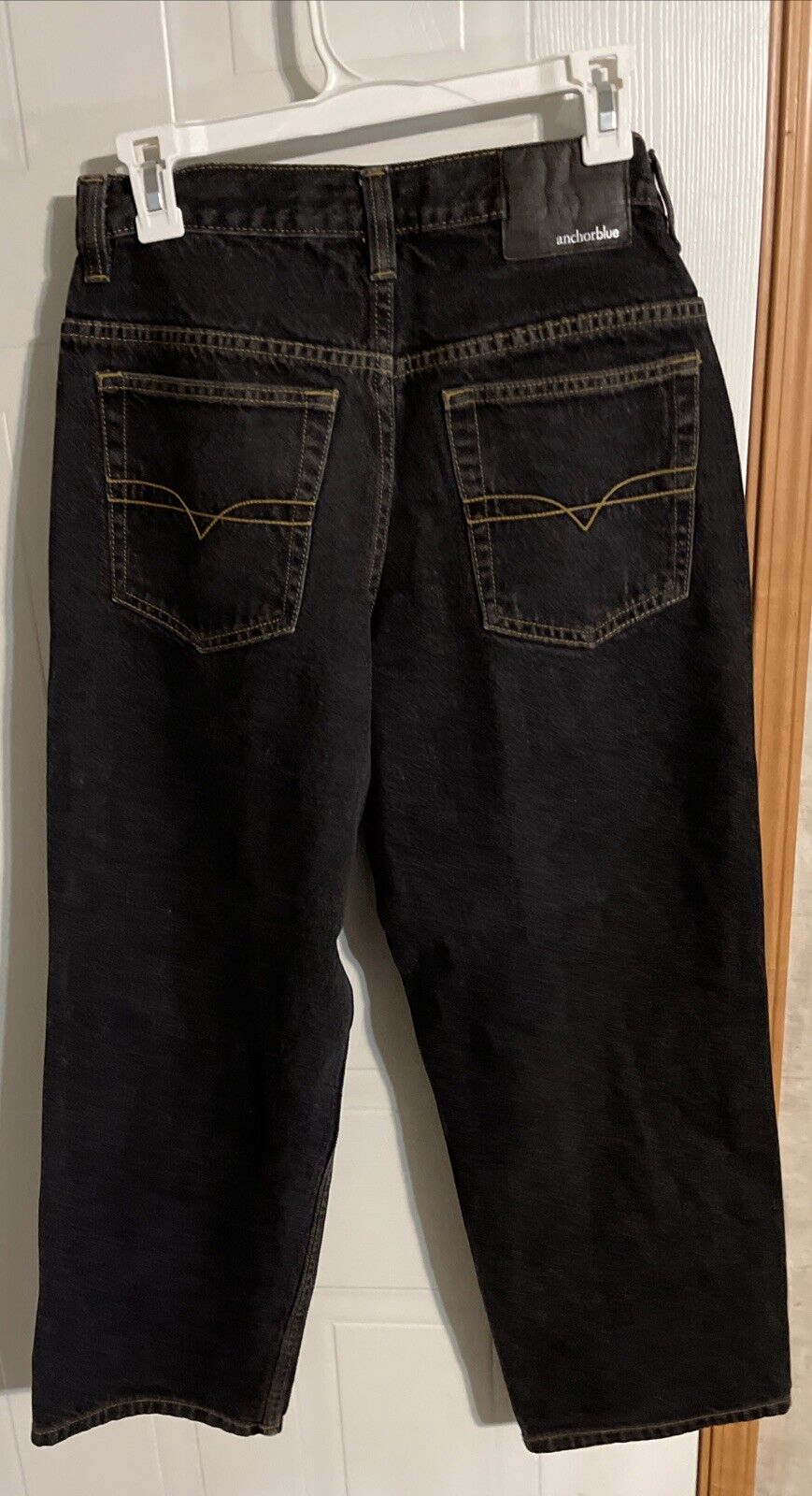 Anchor Blue baggy jeans in black with back pockets and contrast stitching hanging on a white hanger
