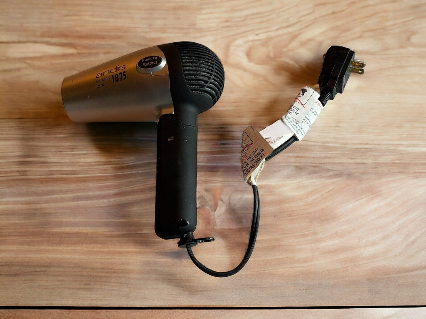 Andis 1875 hair dryer for parts with black handle and silver body showing power cord and plug