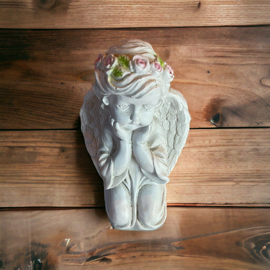White angel figurine for home decor with floral crown sitting on wooden surface