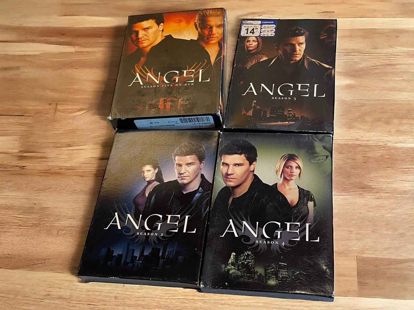 Angel seasons 1-4 DVD lot featuring all four season box sets laid out on a wooden surface