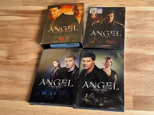 Angel seasons 1-4 DVD lot featuring all four season box sets laid out on a wooden surface