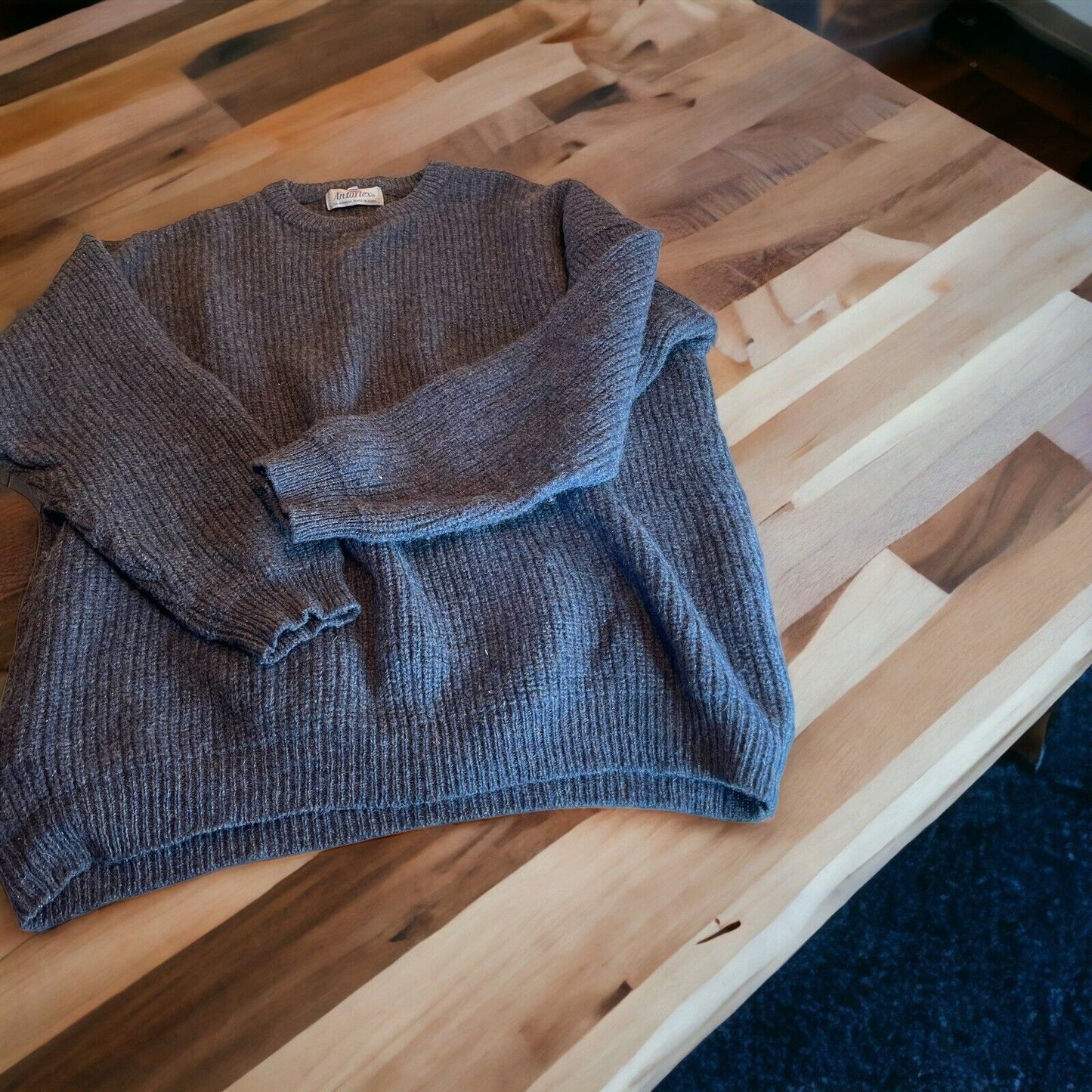 Gray Antartex wool sweater XL laid flat on wooden table showcasing ribbed texture and long sleeves