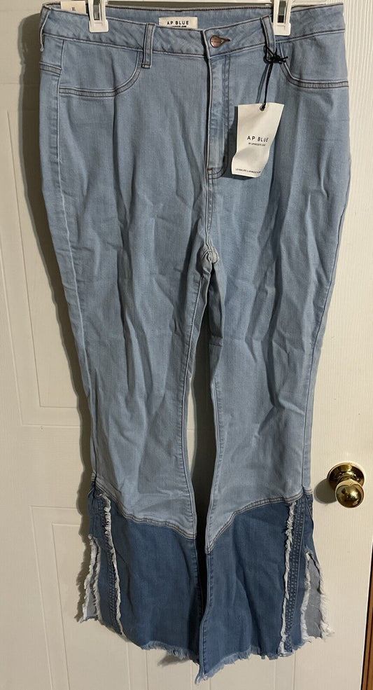Light blue AP brand 1XL trendy jeans with dark denim patchwork and frayed hems hanging on a white door