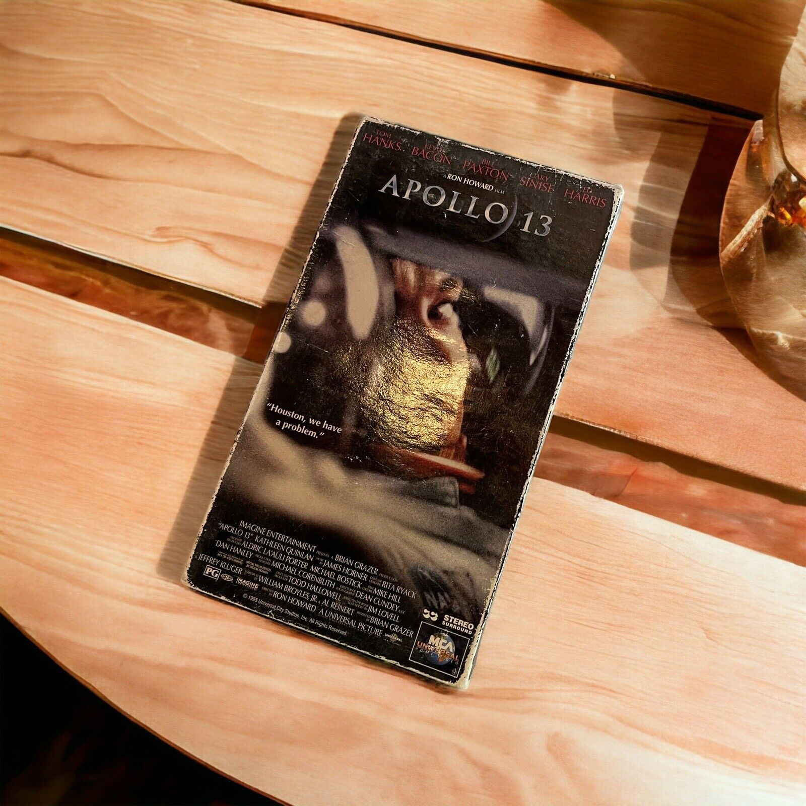 Apollo 13 VHS tape featuring classic movie cover with astronaut helmet on a wooden surface