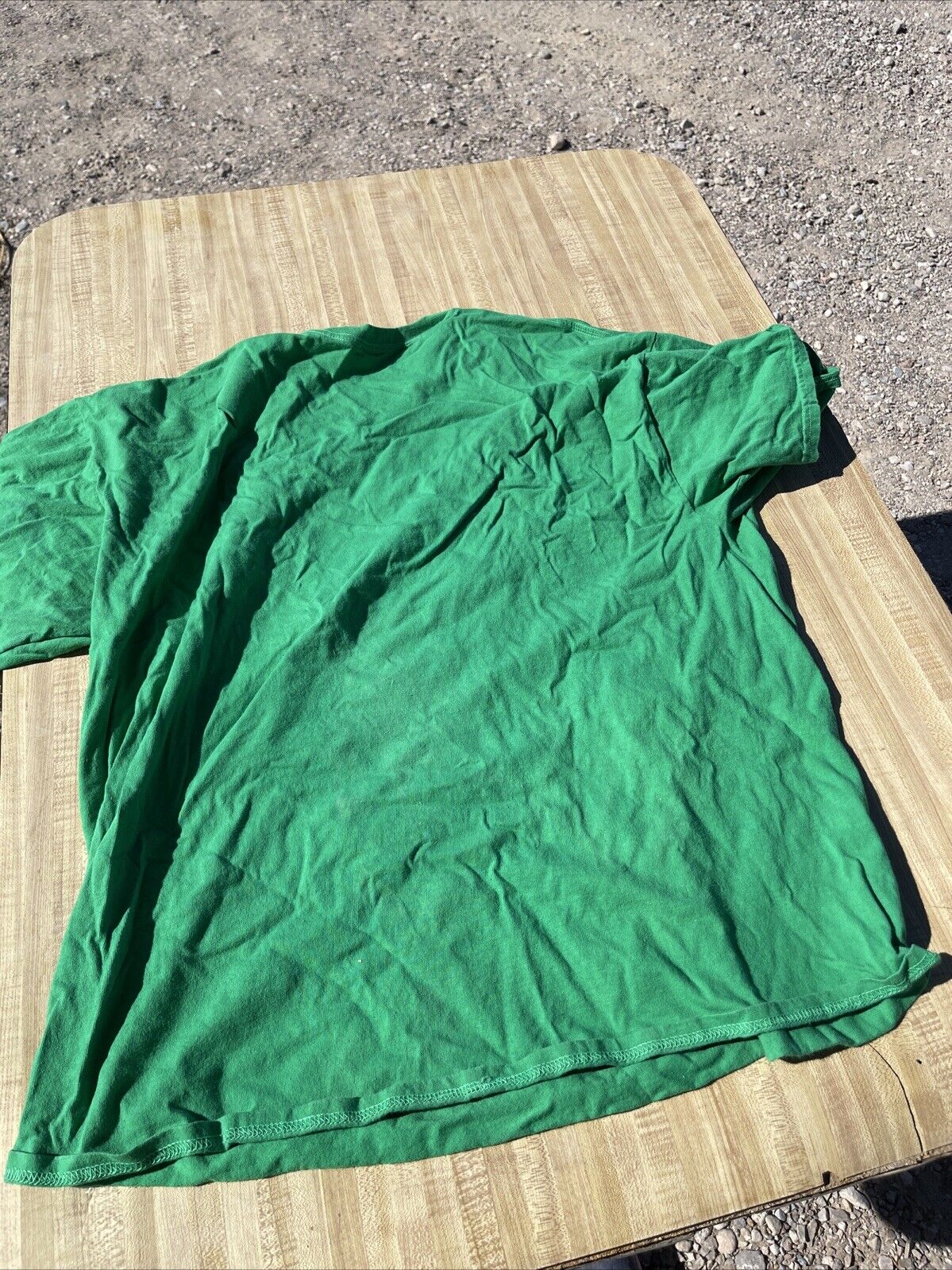 Green Archer graphic t-shirt 2XL laid flat on a wooden surface outdoors