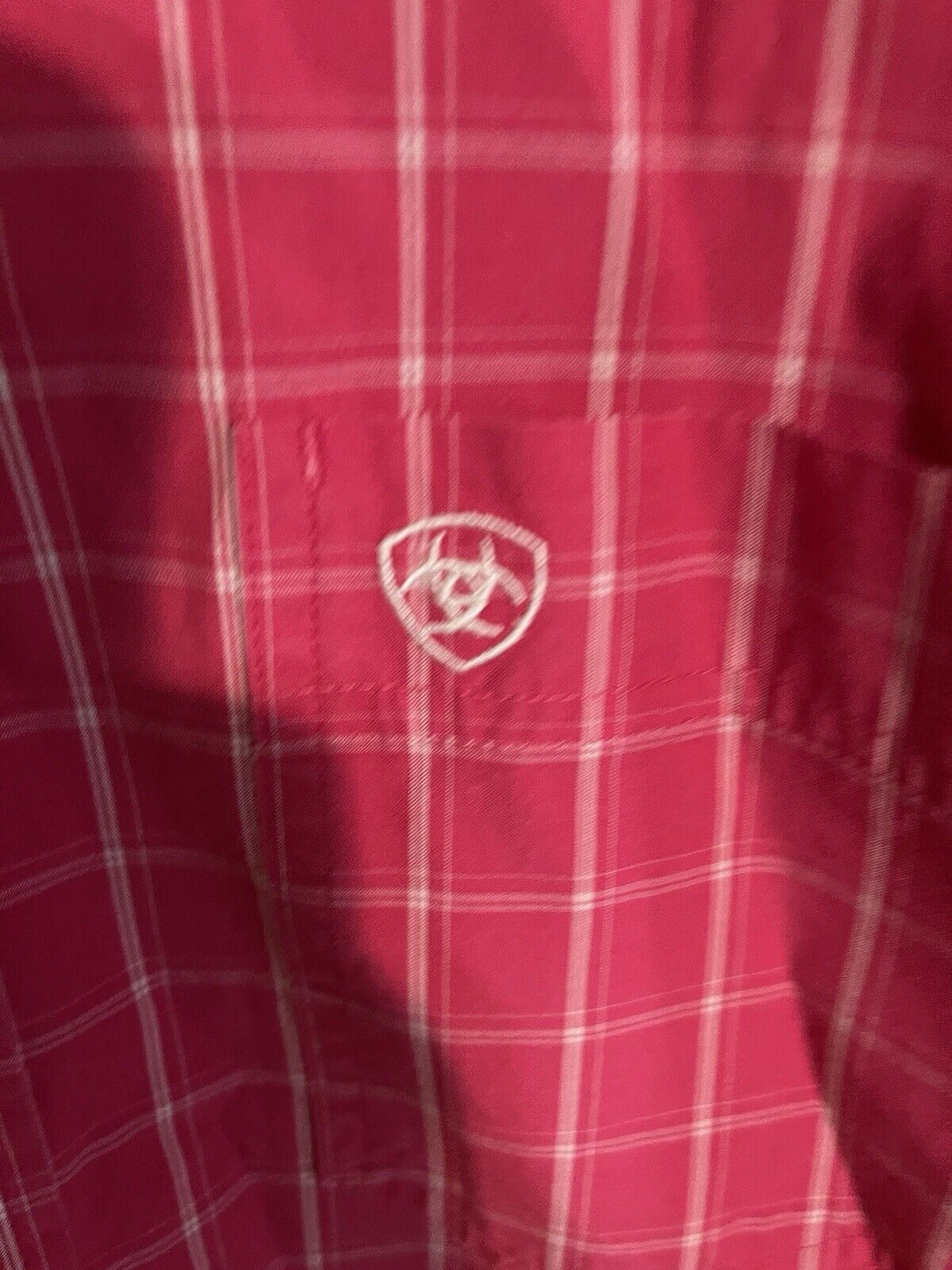 Red plaid Ariat Pro Series shirt with white embroidered logo on chest pocket
