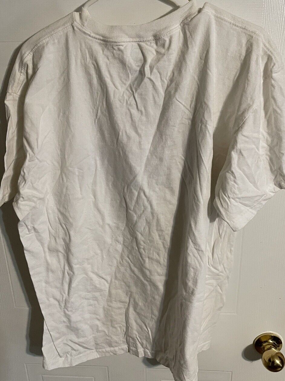 Plain white Arizona Wildcats basketball shirt hanging on a door with wrinkled fabric