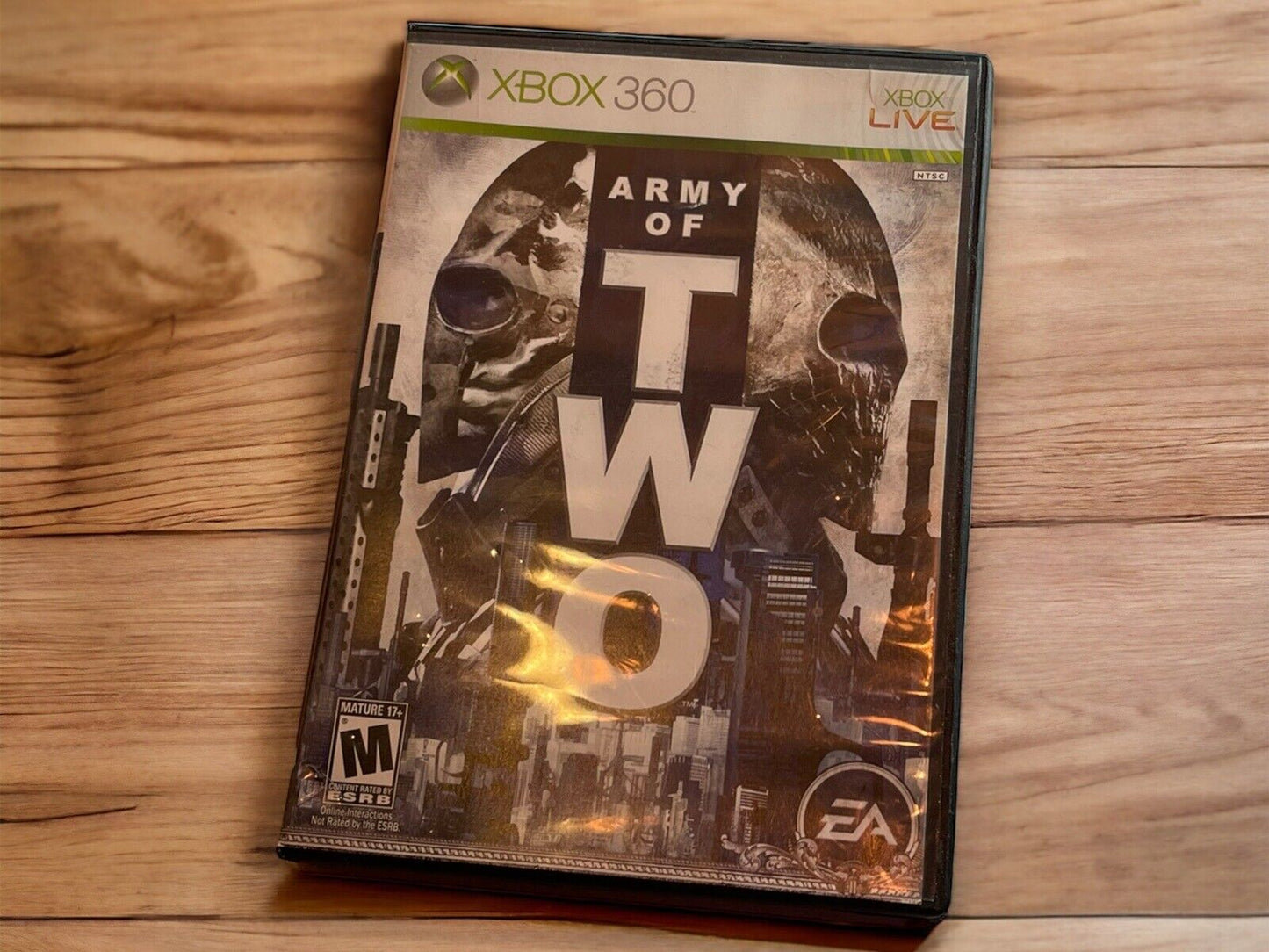 Army of Two Xbox 360 video game case with soldier masks and urban background on wooden surface