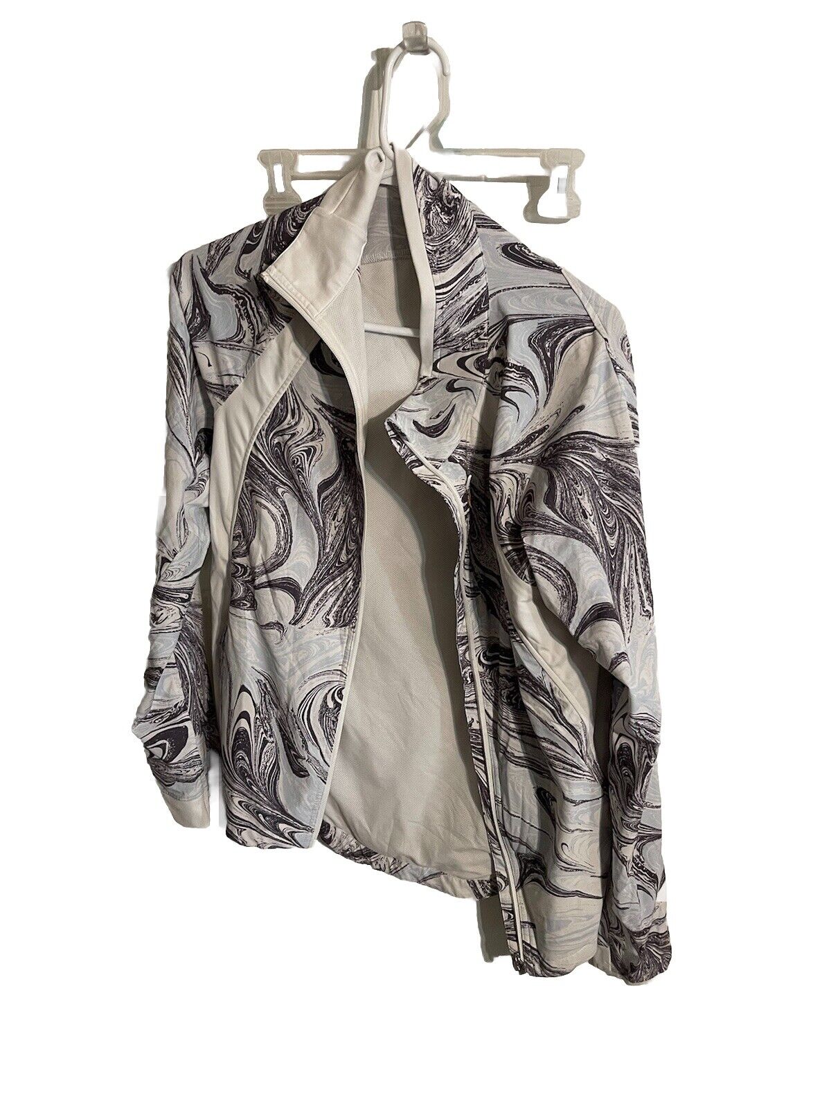 1118 Emporium Athleta full zip jacket large with artistic black and white swirl pattern hanging on white hanger