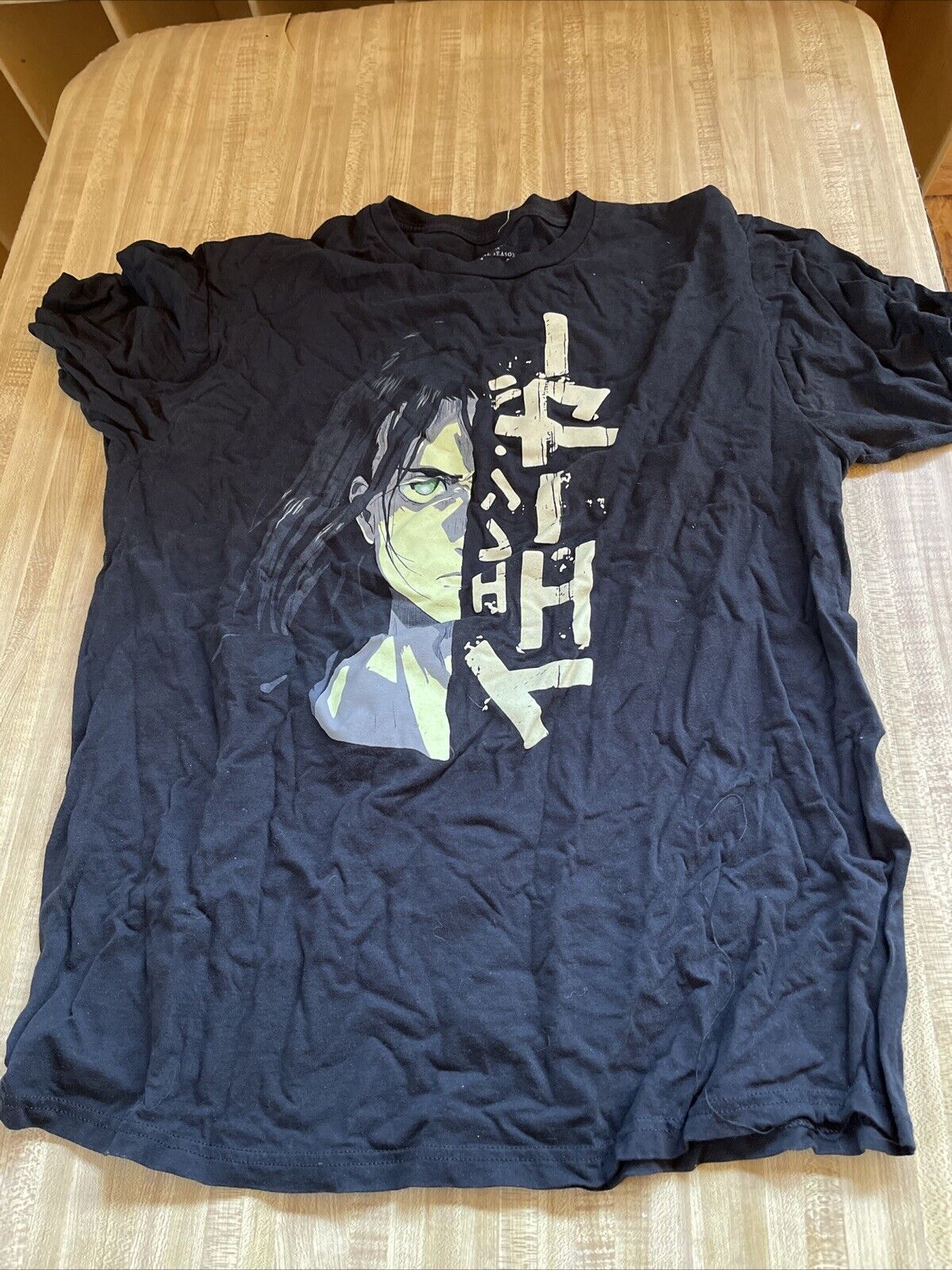 Black Attack on Titan final season t shirt featuring a graphic of a character with green eyes and Japanese text