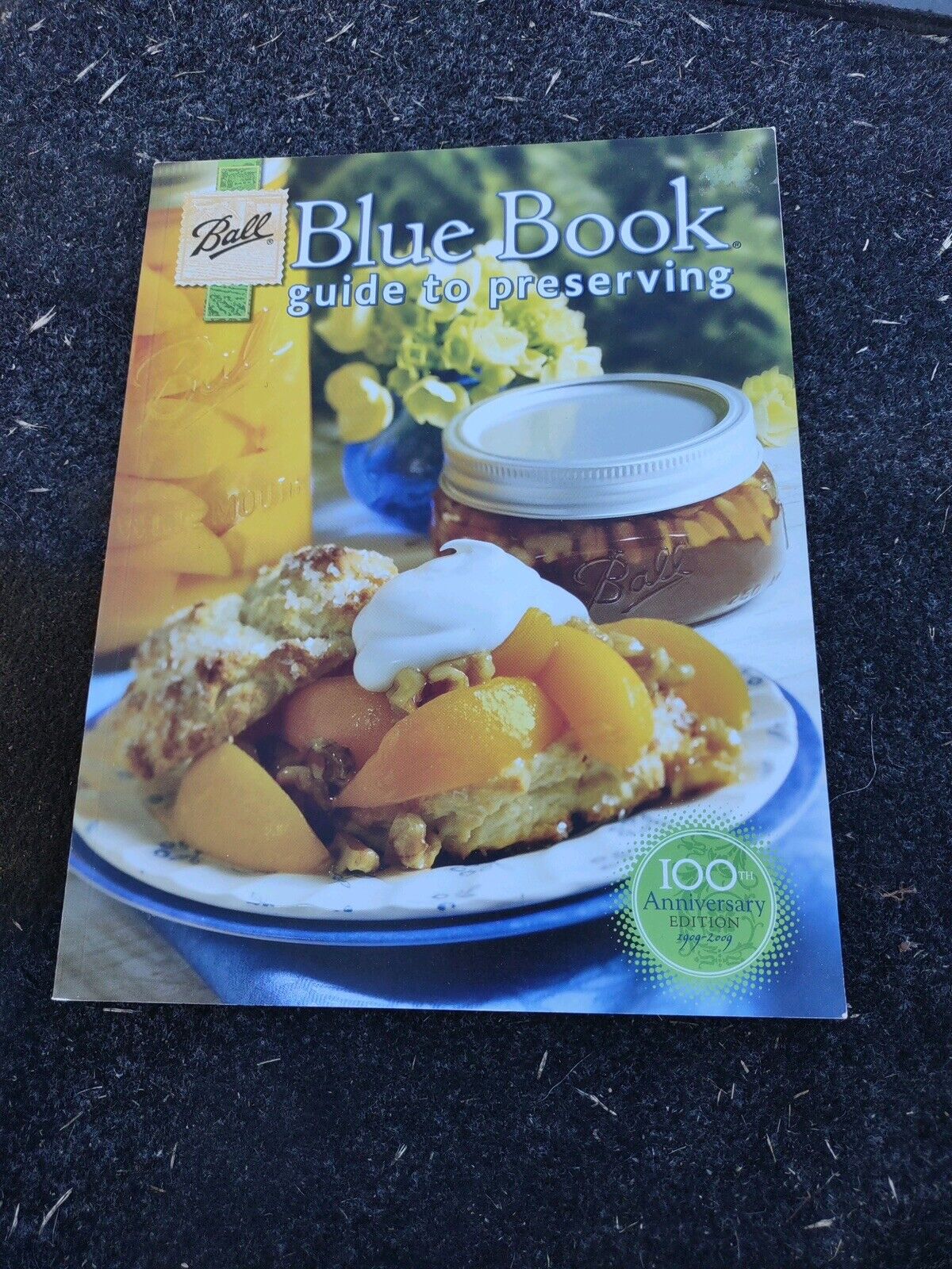 Ball Blue Book Guide to Preserving cookbook showing a peach dessert and a jar of preserved fruit on the cover