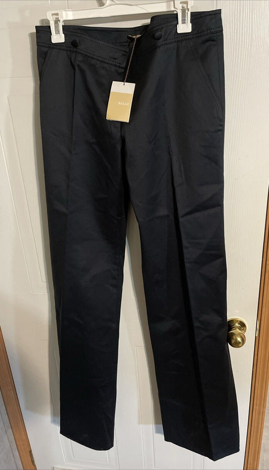 Bally black dress pants hanging on white hanger with tagged label in front of white door