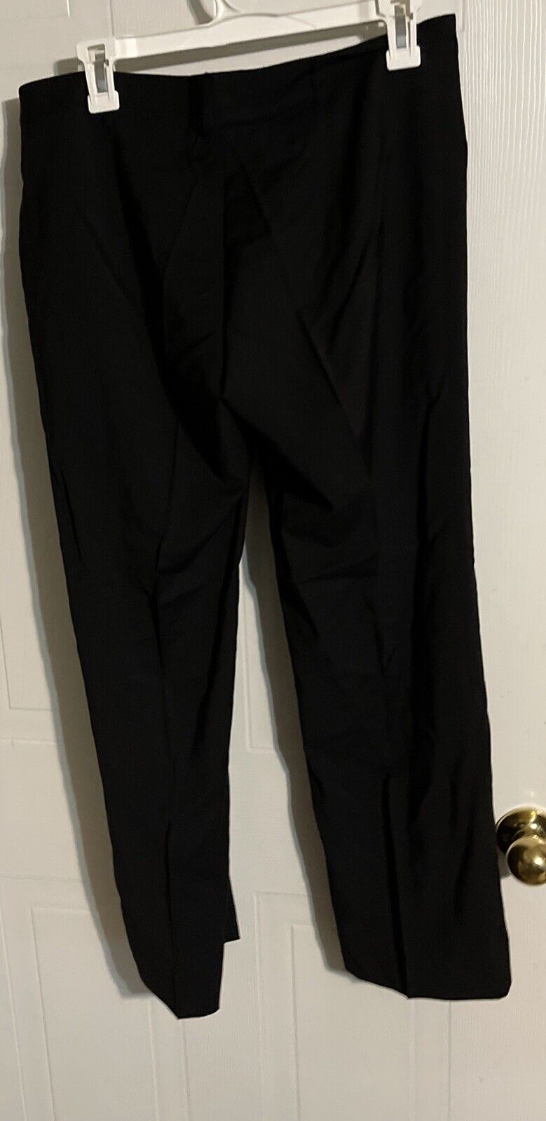 Bally women's black suit pants hanging neatly on a white hanger against a light background