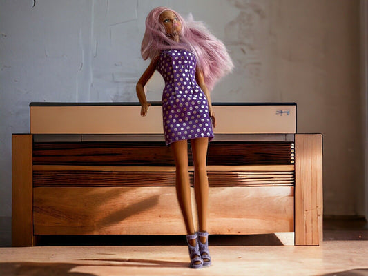 Barbie doll with purple dress featuring white polka dots and matching purple high-heeled shoes