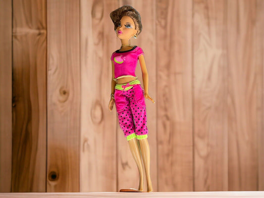 Barbie My Scene Madison doll wearing pink polka dot outfit standing against wooden background