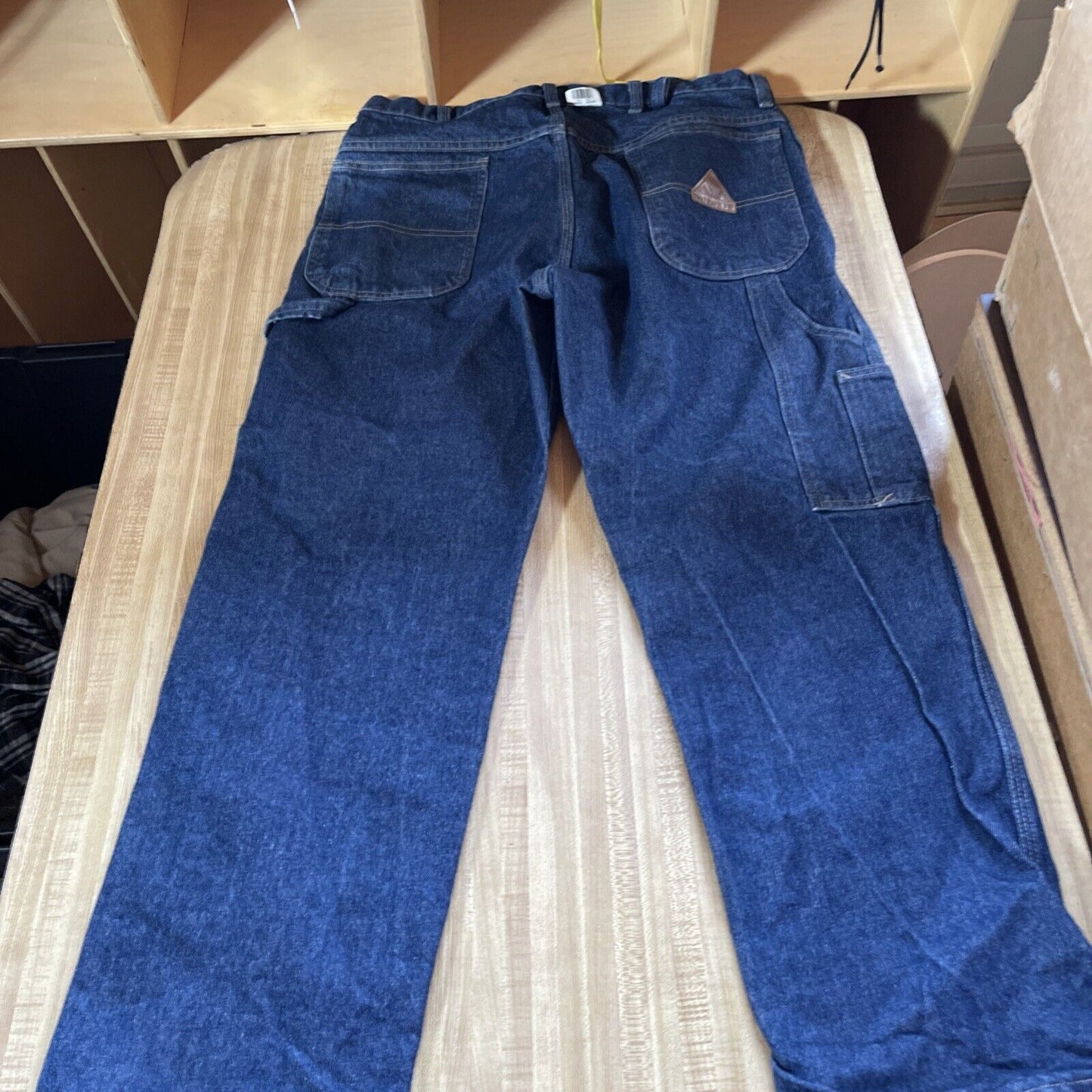 Blue Bulwark FR carpenter jeans laid flat showing front pockets and tool loops