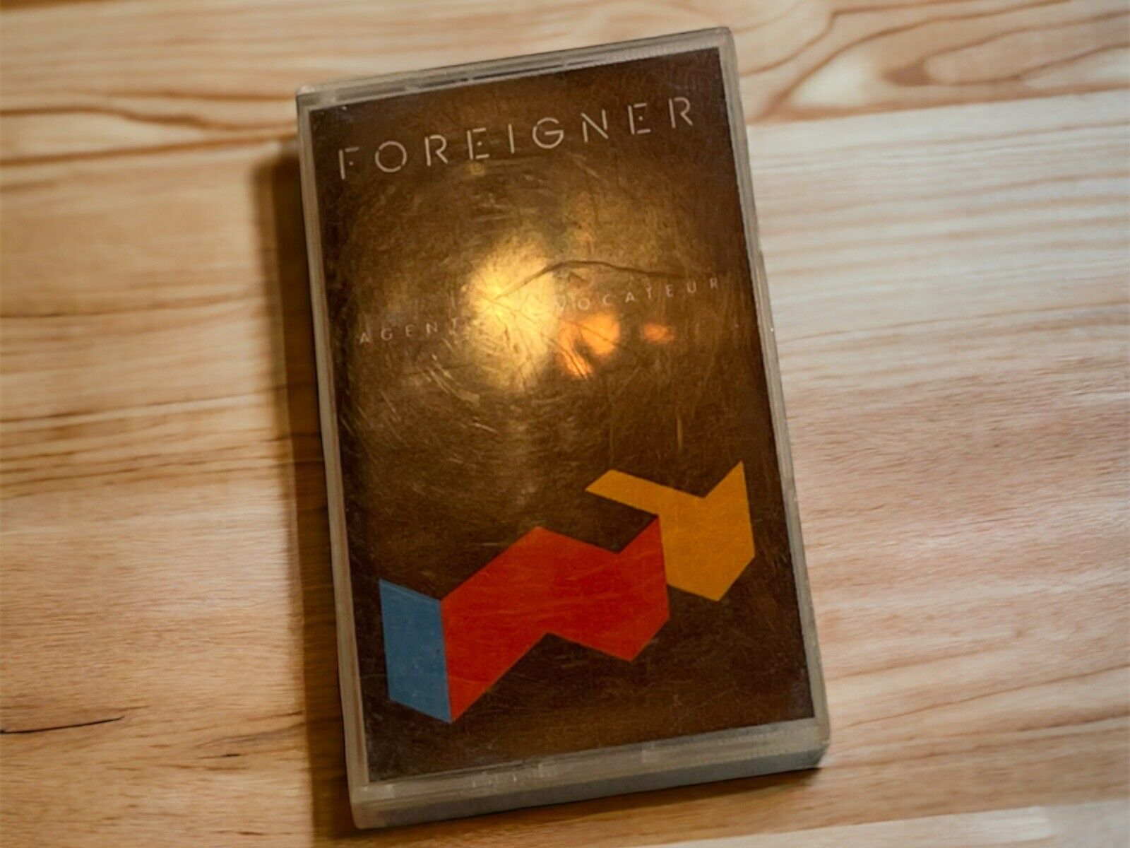 Foreigner Agent Provocateur cassette tape with geometric design on cover placed on wooden surface