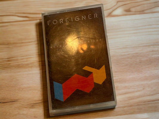 Foreigner Agent Provocateur cassette tape with geometric design on cover placed on wooden surface