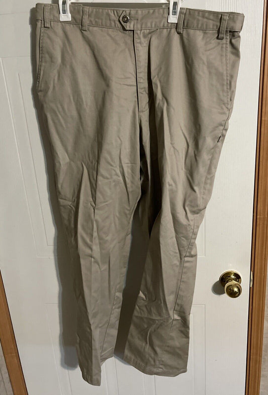 1118 Emporium men's tactical work pants in beige hanging on white door