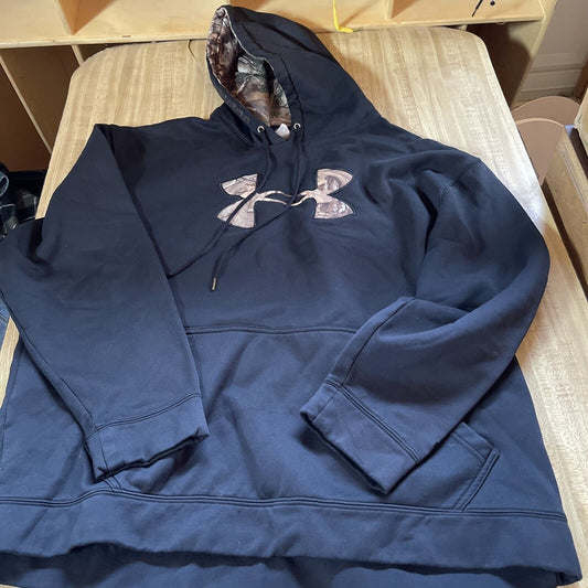 Black Under Armour pullover with camo logo and hood lining laid flat on a wooden surface