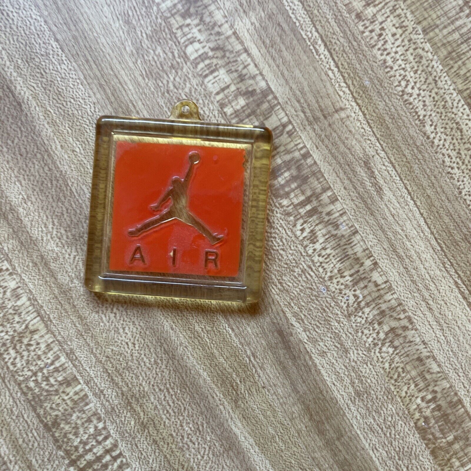 Vintage Air Jordan key fob with clear casing and red Jumpman logo on wood surface