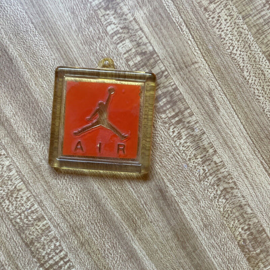 Vintage Air Jordan key fob with clear casing and red Jumpman logo on wood surface