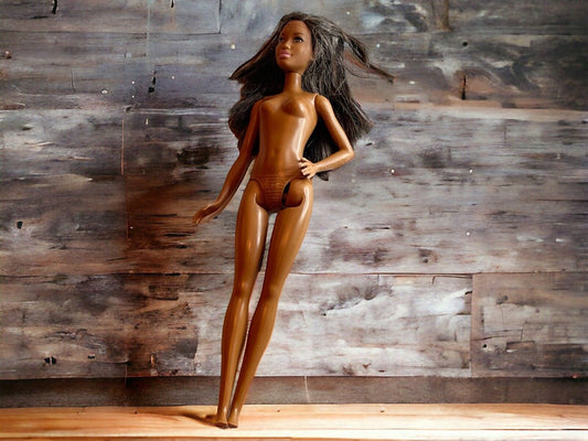 Naked vintage Barbie doll for sale with long brown hair standing against wooden background