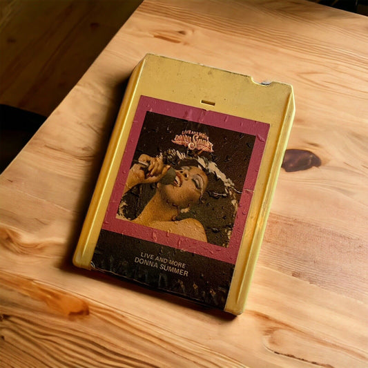 Vintage Live and More tape featuring Donna Summer in yellow 8-track cartridge on wood surface