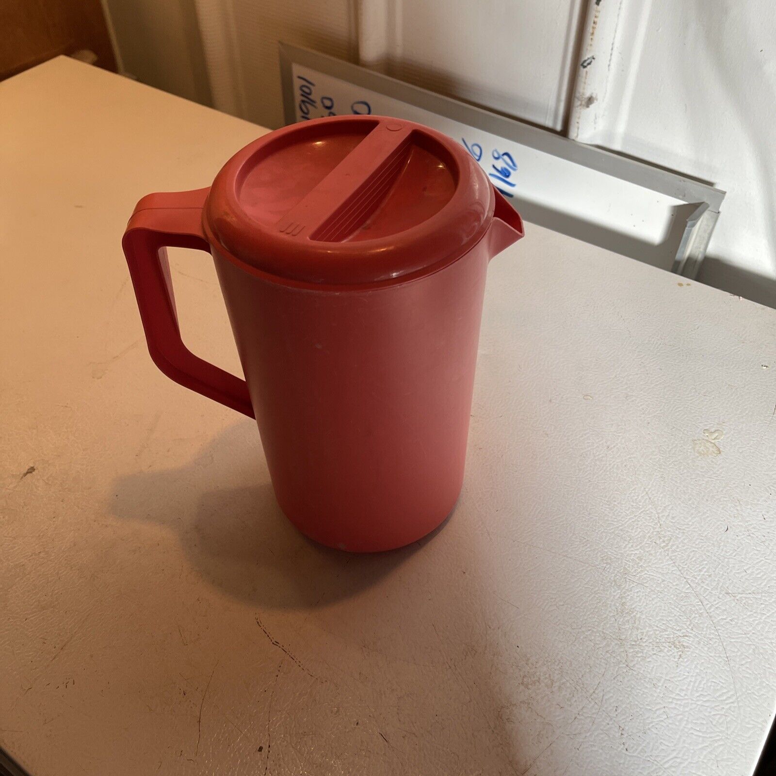 Red vintage Rubbermaid pitcher with handle and lid on white table by 1118 Emporium
