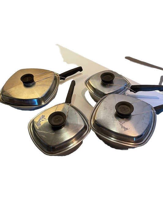 Vintage stainless steel cookware set with four pots and black handles on white background