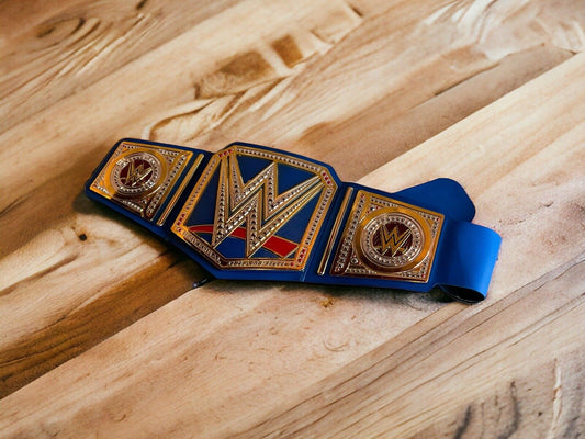 WWE Universal Champion replica belt with gold and blue design placed on wooden surface